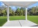 Covered back patio overlooking a green, well-maintained lawn and wooded area at 2044 Copper Creek Ct., Longs, SC 29568