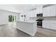 Open-concept kitchen featuring white cabinets, island with sink, and stainless steel appliances at 2044 Copper Creek Ct., Longs, SC 29568