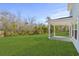 Large backyard with a covered patio and lush green grass, perfect for outdoor activities at 2052 Copper Creek Ct., Longs, SC 29568