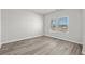 Bright bedroom featuring wood-look flooring and a window offering natural light, complemented by neutral walls at 2052 Copper Creek Ct., Longs, SC 29568
