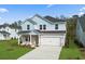 Beautiful two-story home with a well-kept lawn, a two-car garage, and appealing blue and white exterior at 2052 Copper Creek Ct., Longs, SC 29568