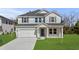 Two-story home showing a well-maintained lawn, a two-car garage, and a stylish mix of siding and brick at 2052 Copper Creek Ct., Longs, SC 29568