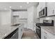 Well-lit kitchen featuring a gas range, microwave, granite countertops, and white cabinetry at 2052 Copper Creek Ct., Longs, SC 29568