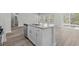 Kitchen island with a sink, dishwasher, and stainless steel faucet in a modernly designed kitchen at 2052 Copper Creek Ct., Longs, SC 29568
