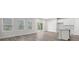 Open living space showcasing wood-look flooring, kitchen island, and natural light from multiple windows and a sliding door at 2052 Copper Creek Ct., Longs, SC 29568