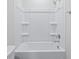 Clean white bathroom showcasing a tub and shower combination with built-in shelving at 2104 Copper Creek Ct., Longs, SC 29568