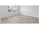 Bright bedroom with light wood flooring, white walls, and a large window at 2104 Copper Creek Ct., Longs, SC 29568