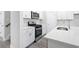 Well-lit kitchen boasts stainless steel appliances, white cabinets, and quartz countertops at 2104 Copper Creek Ct., Longs, SC 29568