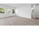 Spacious living room featuring light wood flooring, white walls, and multiple windows at 2104 Copper Creek Ct., Longs, SC 29568