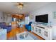 Open living room and dining area leading to kitchen with hardwood floors, sofa, recliners, and large TV at 212 58Th Ave. N # 1C, North Myrtle Beach, SC 29582