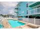 The turquoise condo has a beautiful pool surrounded by a brick patio with lounge chairs and a white privacy fence at 212 58Th Ave. N # 1C, North Myrtle Beach, SC 29582