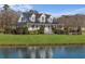 Stunning two-story home features a manicured lawn, covered porch, and pergola next to a pond at 2325 Highway 111, Little River, SC 29566