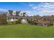 Beautiful two-story home boasts a manicured lawn, covered front porch, and pergola seating area at 2325 Highway 111, Little River, SC 29566