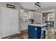 Bright kitchen with white cabinets, blue island, stainless steel appliances, and modern lighting at 2325 Highway 111, Little River, SC 29566