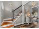 Elegant foyer features a wooden staircase with contrasting black railings and a decorative table at 2325 Highway 111, Little River, SC 29566