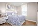 Comfortable bedroom with blue and white bedding, a nightstand, and plenty of natural light at 2521 Rowyn St., Longs, SC 29568