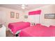 Cozy bedroom featuring two twin beds with bright pink comforters and beach-themed decor at 2602 Perrin Dr., North Myrtle Beach, SC 29582