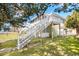 Home exterior featuring an outdoor staircase to an upper level, mature trees and green lawn at 2602 Perrin Dr., North Myrtle Beach, SC 29582