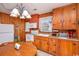 Rustic kitchen with wood paneling, appliances, oak cabinets, and a round breakfast table at 2602 Perrin Dr., North Myrtle Beach, SC 29582