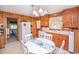Charming kitchen with wood-paneled walls, white appliances, and a dining table for Gathering meals at 2602 Perrin Dr., North Myrtle Beach, SC 29582