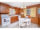 Cozy kitchen features wood-paneled walls, white appliances, and a round table for dining at 2602 Perrin Dr., North Myrtle Beach, SC 29582