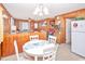 Eat-in kitchen features wood paneling, a white table with four chairs, and white appliances at 2602 Perrin Dr., North Myrtle Beach, SC 29582