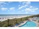 Aerial view of the property's pools near the beach, featuring numerous lounge chairs and palm trees at 2701 S Ocean Blvd. # 1908, North Myrtle Beach, SC 29582
