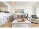 Bright living room featuring a comfortable sofa, accent chair, beach-themed artwork and access to the kitchenette at 2701 S Ocean Blvd. # 1908, North Myrtle Beach, SC 29582