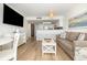 Open floor plan living room with a comfortable sofa, dining table, television, and bar stool seating at 2701 S Ocean Blvd. # 1908, North Myrtle Beach, SC 29582
