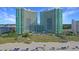 Beautiful beachside condo complex with manicured dunes and ocean views under clear blue skies at 300 N Ocean Blvd. # 1026, North Myrtle Beach, SC 29582