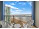 Balcony view from this condo shows the ocean and beach from above with comfortable seating at 300 N Ocean Blvd. # 1026, North Myrtle Beach, SC 29582