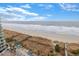 This beach view showcases the ocean, a beach access walkway, and a few places to sit at 300 N Ocean Blvd. # 1026, North Myrtle Beach, SC 29582