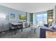 Well-decorated living room with a sofa, dining table, TV, and balcony access with an ocean view at 300 N Ocean Blvd. # 1026, North Myrtle Beach, SC 29582