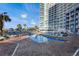 Outdoor resort pool area featuring lounge seating, palm trees, and a clear blue sky at 300 N Ocean Blvd. # 1026, North Myrtle Beach, SC 29582