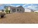 A landscaped backyard featuring well-maintained grass, shrubs, and neighboring houses at 310 Junco Circle, Longs, SC 29568