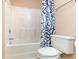 Bathroom features a white tub and toilet complemented by blue-patterned shower curtain at 310 Junco Circle, Longs, SC 29568
