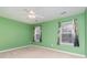 Bedroom featuring green walls, ceiling fan, and two windows with decorative curtains at 310 Junco Circle, Longs, SC 29568