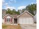 Charming single-story home featuring a well-maintained lawn, two-car garage, and inviting front porch at 310 Junco Circle, Longs, SC 29568