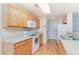 Efficient kitchen with wood cabinets, white appliances, and a functional layout at 310 Junco Circle, Longs, SC 29568
