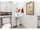 Charming powder room featuring a pedestal sink, oval mirror, decorative art, and a wood-look floor at 378 Dunbarton Ln., Conway, SC 29526