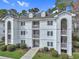 Charming condo building featuring multiple balconies, dormer windows, and well-maintained landscaping at 4257 Villas Dr. # 106, Little River, SC 29566