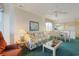 Living room open to dining area features a floral sofa and bright windows at 4257 Villas Dr. # 106, Little River, SC 29566