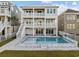 Beautiful elevated beach house featuring private pool, multiple decks, outdoor stairway, and manicured lawn at 4843 Williams Island Dr., Little River, SC 29566