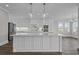 Bright kitchen features a large island, stainless steel appliances, and modern pendant lighting at 4843 Williams Island Dr., Little River, SC 29566