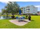 Outdoor dining area featuring blue patio furniture, grills, and lakeside views at 4875 Luster Leaf Circle # 202, Myrtle Beach, SC 29577