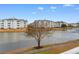 Relaxing lake view with well-kept landscaping and multi-story building in the background at 4875 Luster Leaf Circle # 202, Myrtle Beach, SC 29577