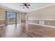 Bright living area featuring sliding door access to the balcony, hardwood floors, and ceiling fan at 4875 Luster Leaf Circle # 202, Myrtle Beach, SC 29577