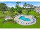 Relaxing community pool with lounge chairs, umbrellas, and a manicured lawn at 4875 Luster Leaf Circle # 202, Myrtle Beach, SC 29577