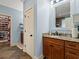 Bathroom featuring wooden cabinets, granite counters, tile floors, and access to the large walk-in closet at 489 Harbour View Dr., Myrtle Beach, SC 29579
