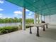 Covered patio featuring grand columns, a dark teal ceiling, and a beautiful lake view at 489 Harbour View Dr., Myrtle Beach, SC 29579